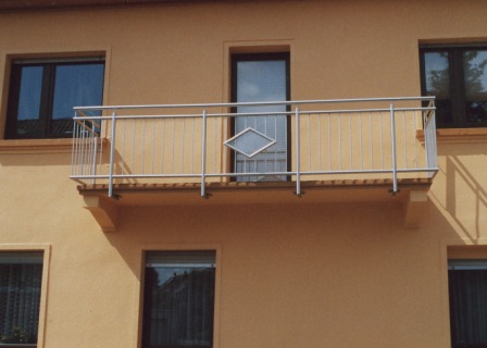 Balkongeländer in Edelstahl an einem Neubau mit senkrechten Stäben und einem Ornament