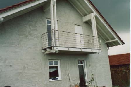Balkongeländer in Edelstahl vor zwei Fenstern